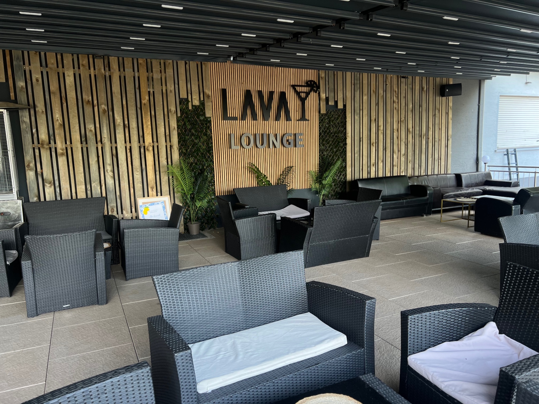 Lava Lounge Schriftzug an der Holzwand im Außenbereich